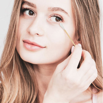 Girl removing eyeliner with a cotton bud